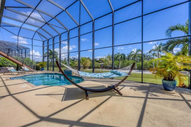 view of swimming pool featuring a patio area and a lanai