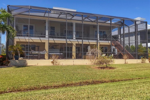 rear view of property with glass enclosure and a yard