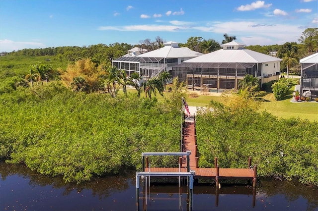 dock area featuring a lawn, glass enclosure, and a water view