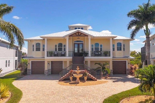 view of front of property with french doors, a porch, and a garage