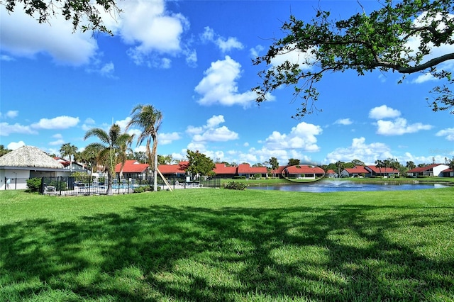 view of home's community featuring a lawn and a water view