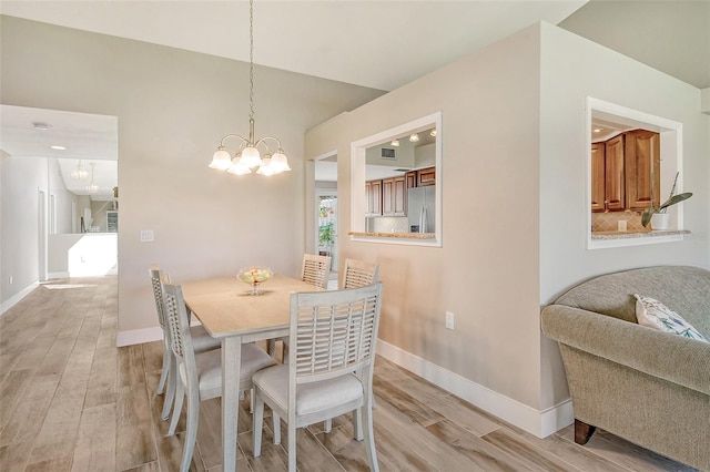 dining room featuring a notable chandelier and light hardwood / wood-style flooring