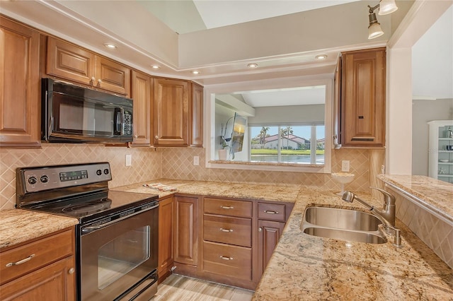 kitchen with light stone countertops, decorative backsplash, range with electric cooktop, and sink