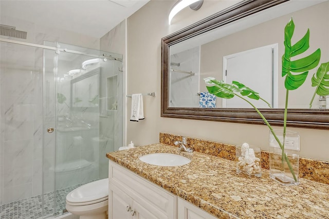 bathroom featuring vanity, toilet, and a shower with door