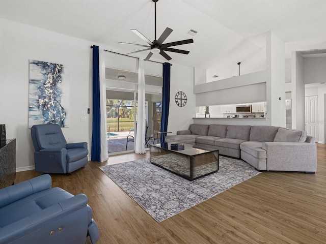 living room with ceiling fan, high vaulted ceiling, and hardwood / wood-style flooring