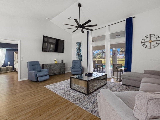 living room featuring ceiling fan, hardwood / wood-style floors, and vaulted ceiling