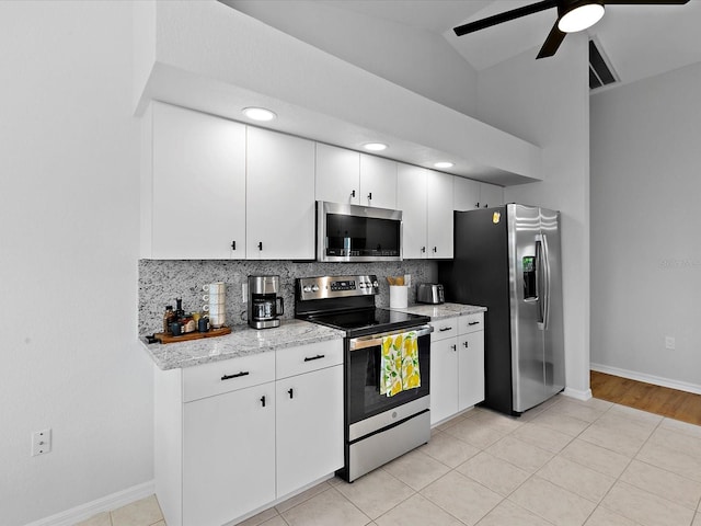 kitchen with white cabinets, appliances with stainless steel finishes, backsplash, and lofted ceiling