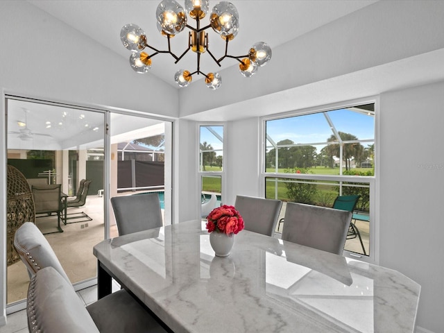 dining room featuring ceiling fan with notable chandelier and vaulted ceiling