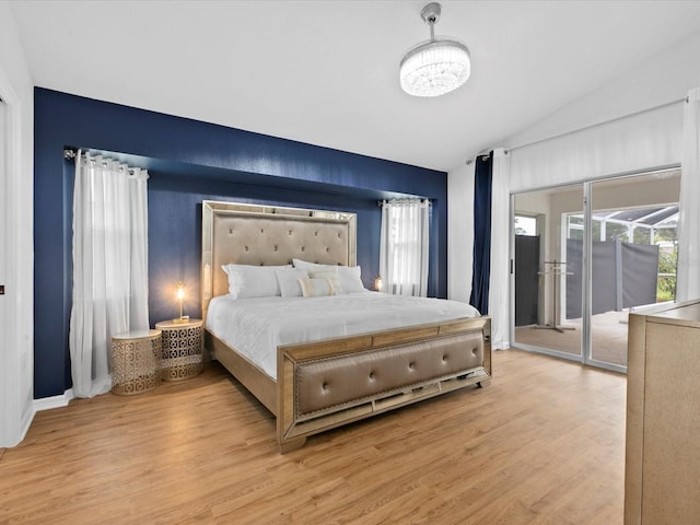 bedroom featuring light hardwood / wood-style floors, access to outside, and vaulted ceiling