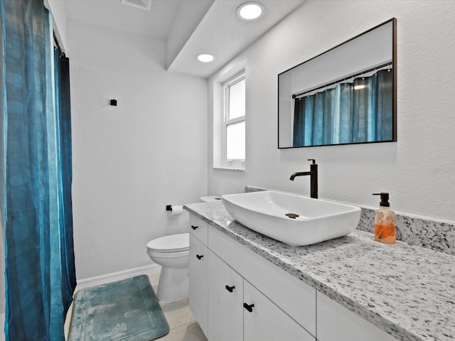 bathroom with tile patterned flooring, vanity, and toilet