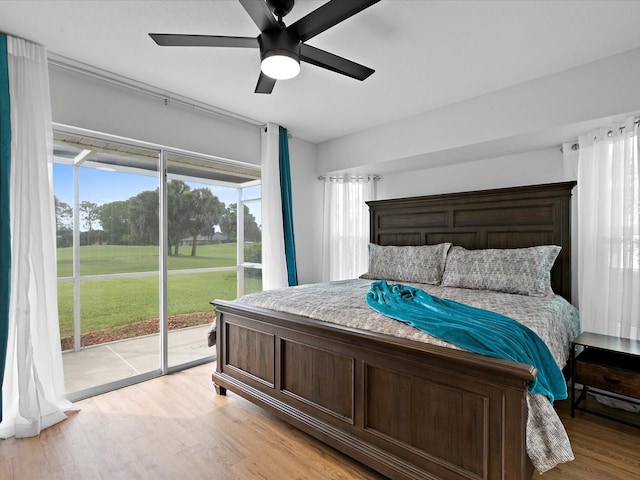 bedroom with light wood-type flooring, access to outside, and ceiling fan