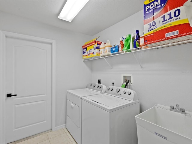 laundry area featuring independent washer and dryer, sink, and light tile patterned floors