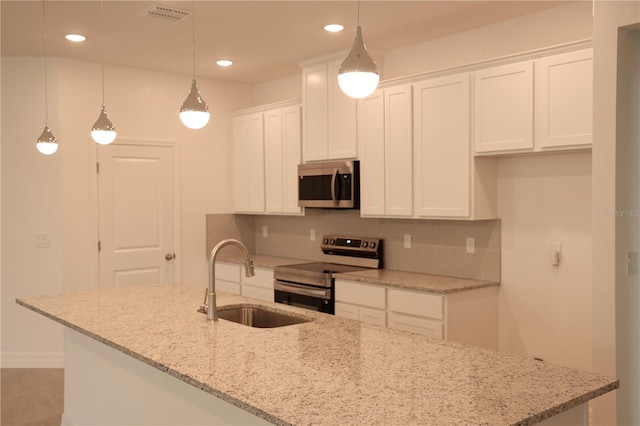 kitchen with light stone countertops, stainless steel appliances, sink, decorative light fixtures, and white cabinetry