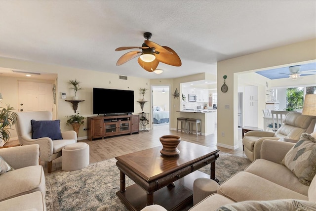 living room with light hardwood / wood-style floors and ceiling fan