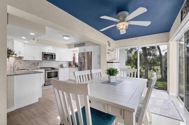 dining space featuring ceiling fan, plenty of natural light, sink, and light hardwood / wood-style flooring