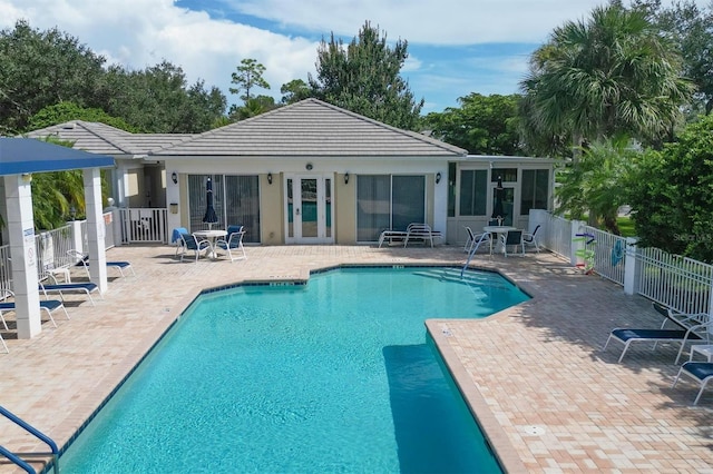 view of swimming pool featuring a sunroom and a patio