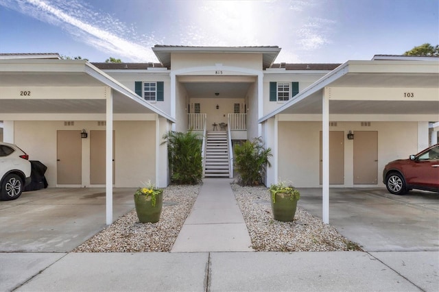 815 Montrose Dr Unit 103, Venice, FL 34293 - view of front facade with stucco siding, stairway, and covered parking