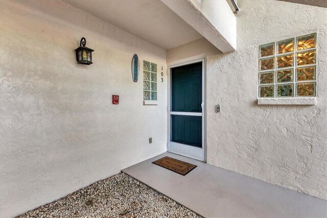 815 Montrose Dr Unit 103, Venice, FL 34293 - doorway to property featuring stucco siding