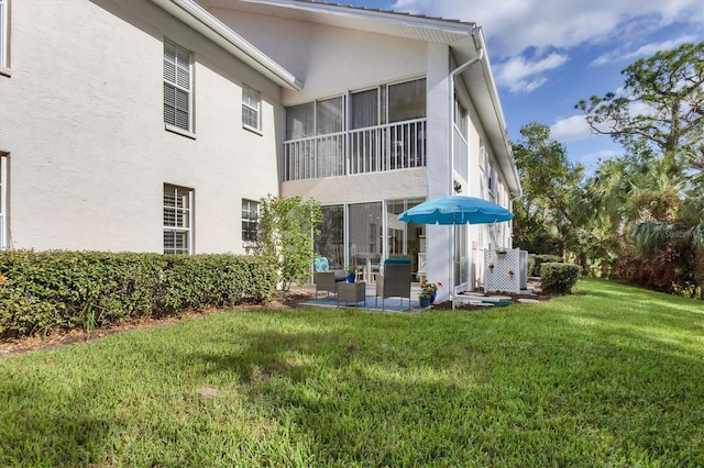 815 Montrose Dr Unit 103, Venice, FL 34293 - rear view of property featuring stucco siding, a yard, a patio area, and outdoor lounge area