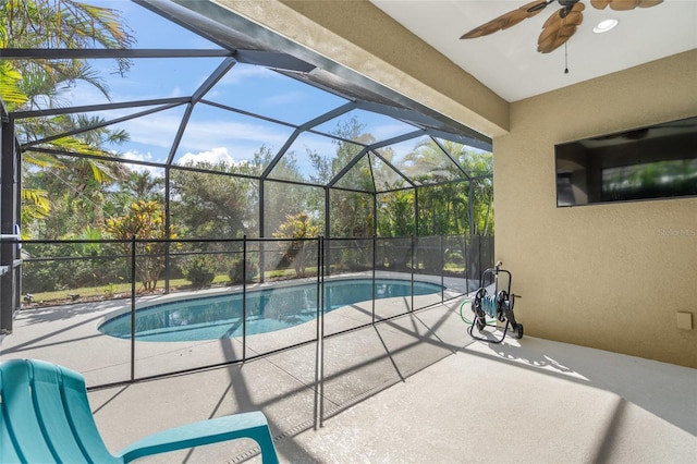 view of pool featuring a patio area, ceiling fan, and glass enclosure