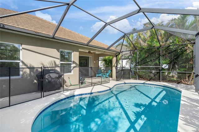 view of swimming pool featuring ceiling fan, area for grilling, a lanai, and a patio