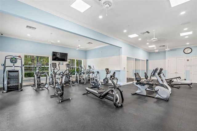 workout area featuring ceiling fan and ornamental molding