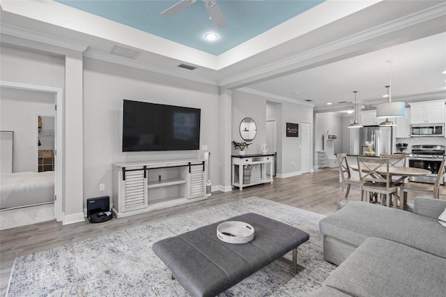 living room featuring ceiling fan, crown molding, and hardwood / wood-style flooring