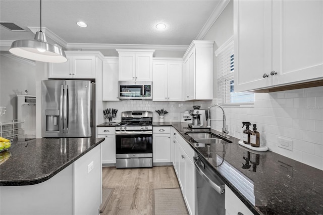 kitchen with white cabinetry, pendant lighting, stainless steel appliances, and sink