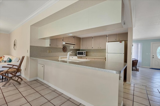 kitchen with kitchen peninsula, decorative backsplash, ornamental molding, light tile patterned floors, and white fridge