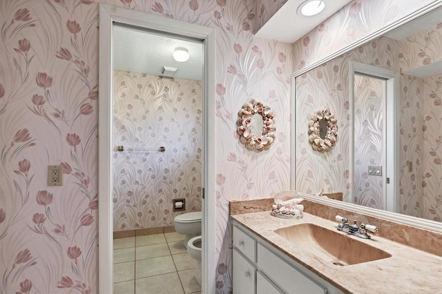 bathroom with toilet, vanity, tile patterned floors, and a bidet