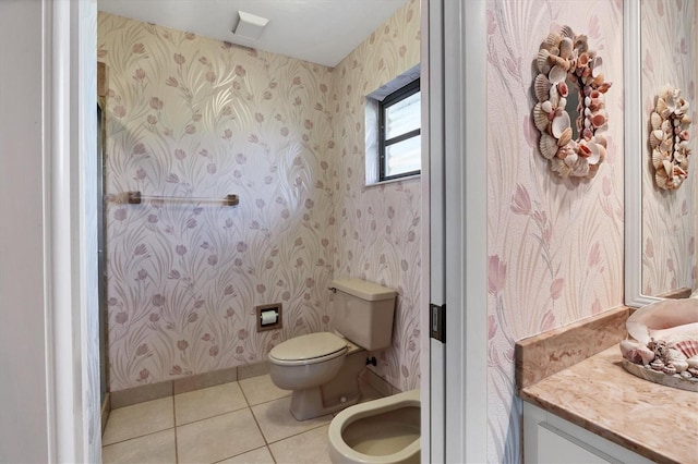 bathroom featuring tile patterned floors, toilet, and a bidet