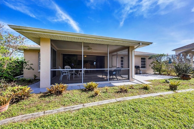 back of property with a sunroom and a yard