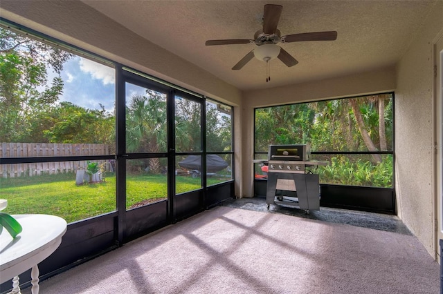 unfurnished sunroom featuring ceiling fan