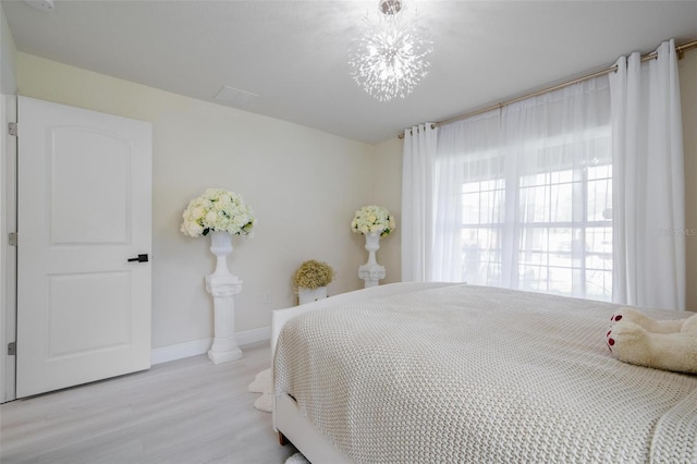 bedroom featuring a notable chandelier and light wood-type flooring