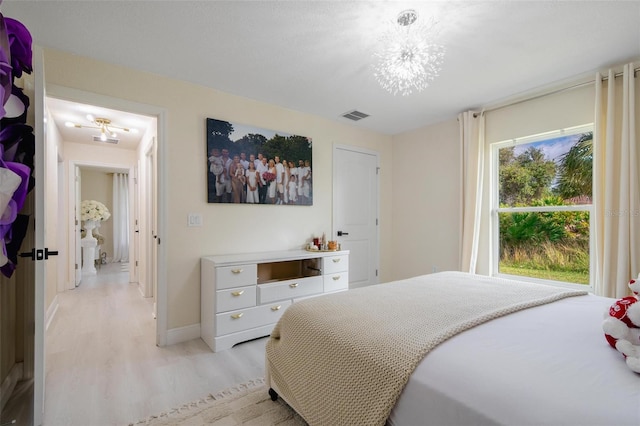 bedroom featuring light hardwood / wood-style flooring and an inviting chandelier