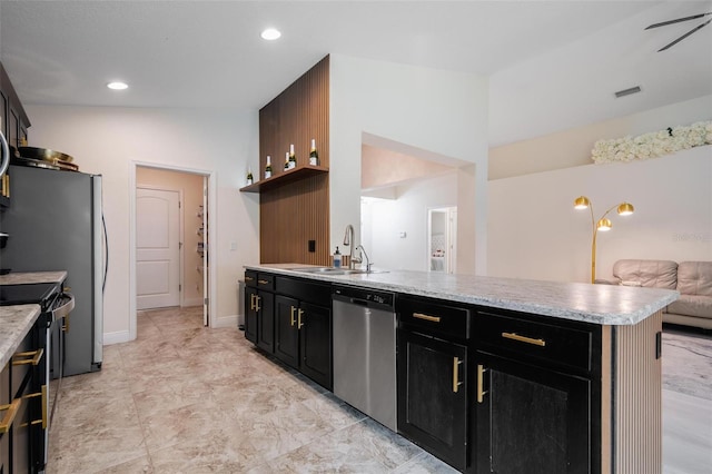 kitchen with ceiling fan, sink, a center island, vaulted ceiling, and appliances with stainless steel finishes