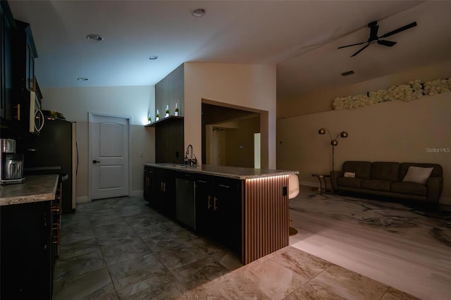 kitchen featuring a breakfast bar, ceiling fan, sink, and lofted ceiling