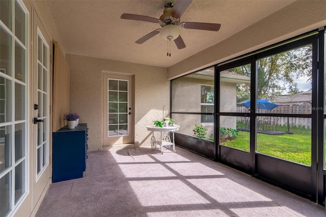 unfurnished sunroom with ceiling fan