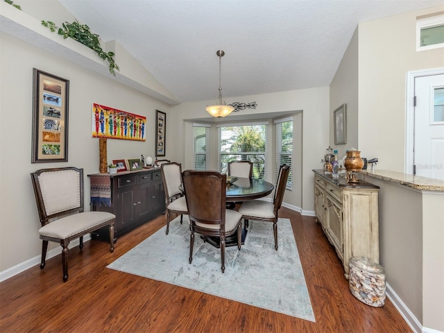 dining room featuring vaulted ceiling and dark hardwood / wood-style floors