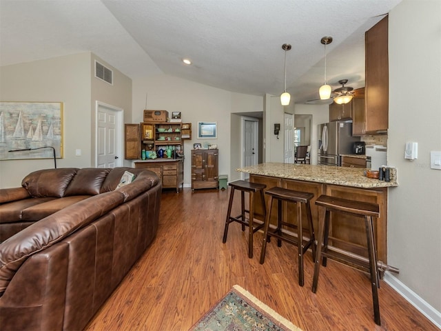 living room featuring dark hardwood / wood-style floors, ceiling fan, and lofted ceiling