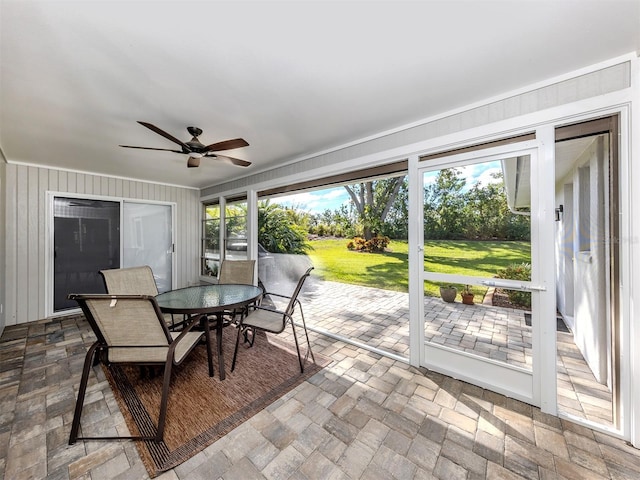 unfurnished sunroom featuring ceiling fan and a healthy amount of sunlight