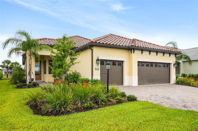 mediterranean / spanish-style house with a garage and a front lawn