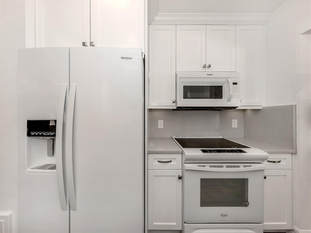 kitchen featuring white cabinets and white appliances