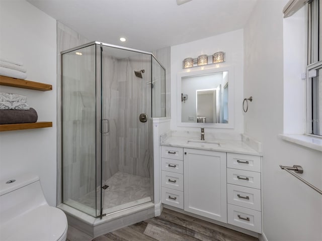 bathroom featuring vanity, hardwood / wood-style flooring, toilet, and walk in shower