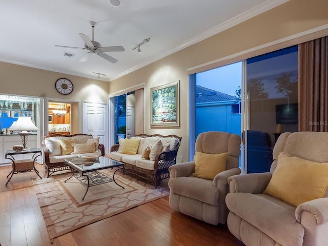 living room with hardwood / wood-style floors, ceiling fan, a healthy amount of sunlight, and ornamental molding