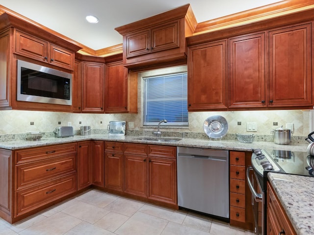 kitchen featuring appliances with stainless steel finishes, backsplash, light stone counters, sink, and light tile patterned flooring