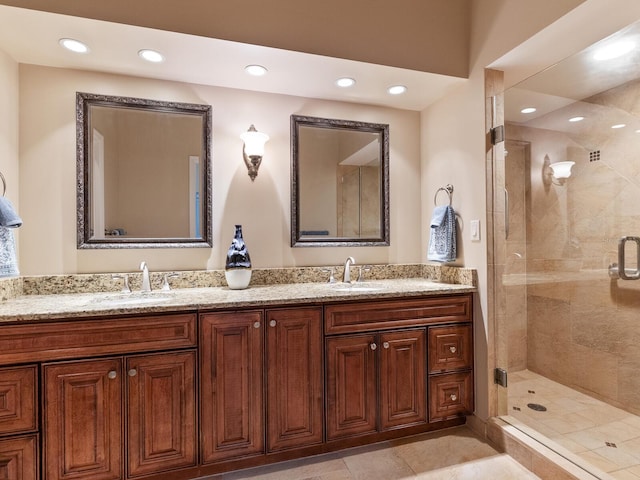 bathroom with tile patterned flooring, vanity, and a shower with door