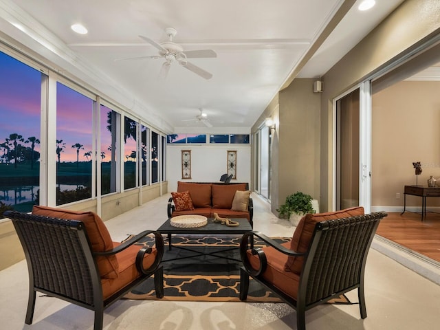 sunroom / solarium featuring ceiling fan and a water view