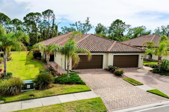 mediterranean / spanish-style house featuring a garage and a front lawn