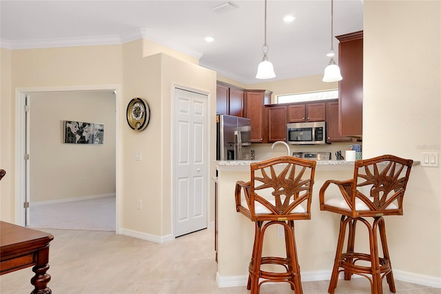 kitchen featuring pendant lighting, a breakfast bar, ornamental molding, kitchen peninsula, and stainless steel appliances